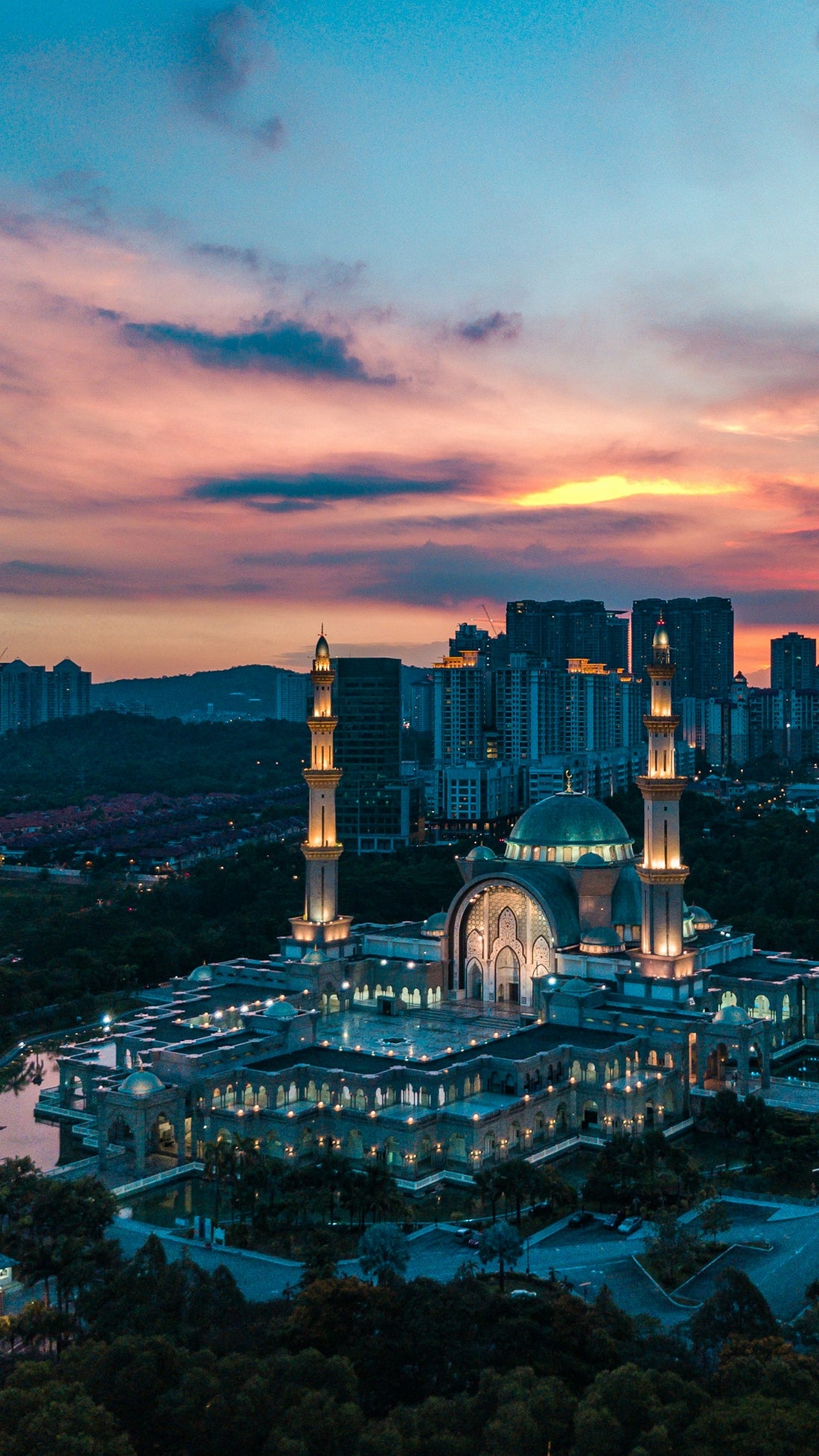Masjid Wilayah Persekutuan in Kuala Lumpur under a warm orange sky at low sun