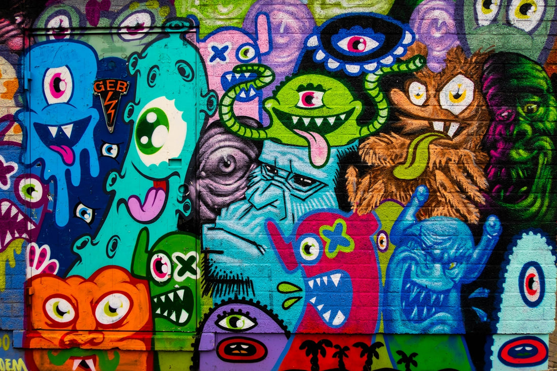 Colorful graffiti mural featuring various cartoon monsters with wide eyes and sharp teeth